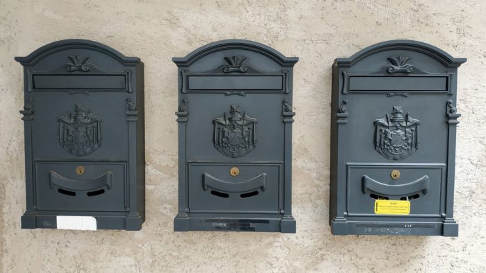 Three vintage-style wall-mounted mailboxes with lockable slots