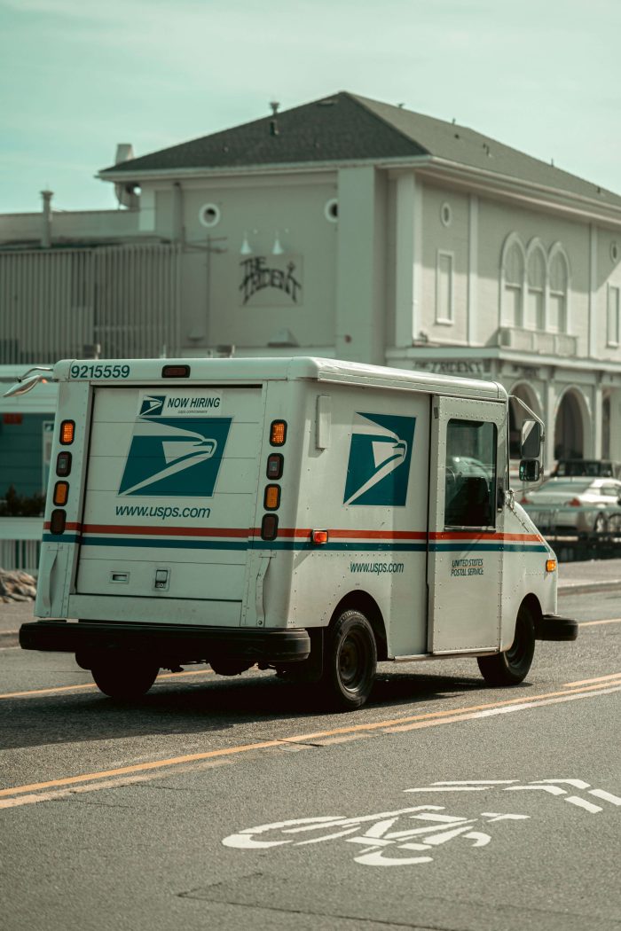 USPS mail truck driving down a street